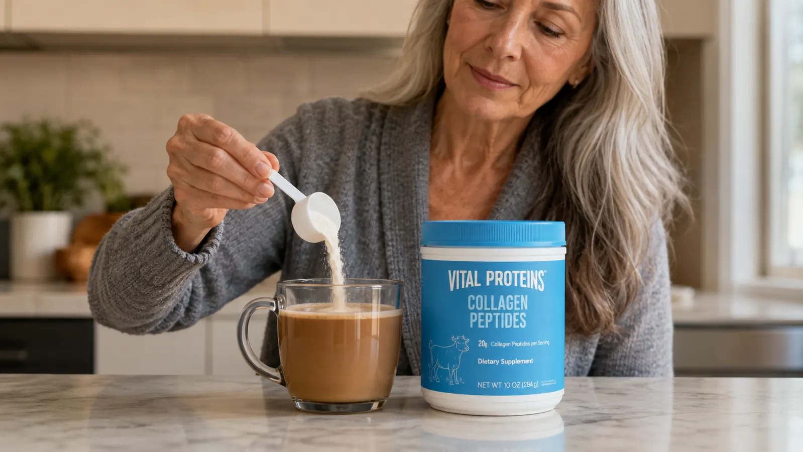 A hand scooping collagen powder from a Vital Proteins jar into a mug of coffee